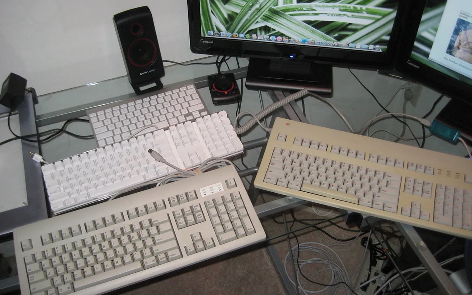 Several computer keyboards lined up on a desk
