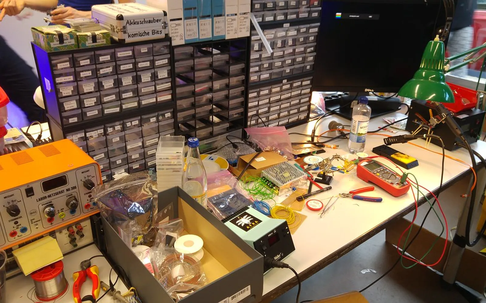 A repair workbench with tools, a multimeter and spare parts