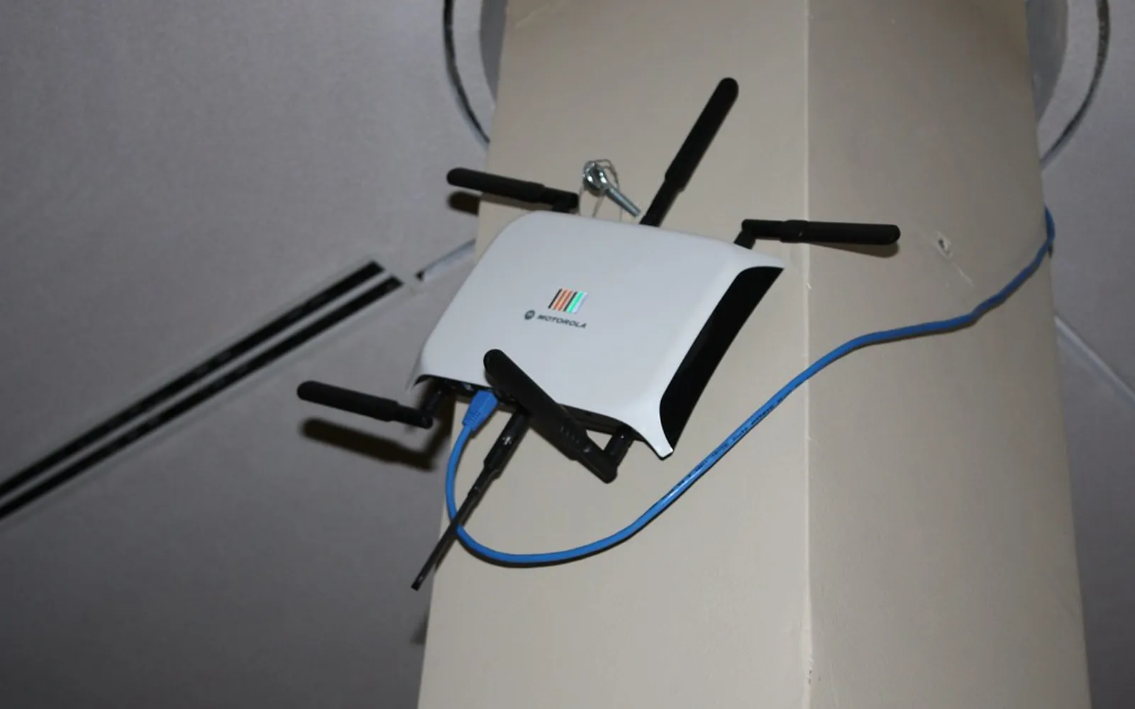 A small wireless router with antennas mounted on a wall